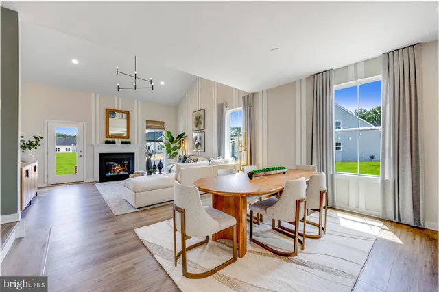 a view of a dining room with furniture a chandelier and wooden floor