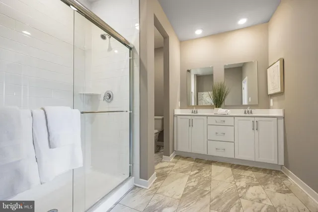 a bathroom with a granite countertop sink mirror and shower