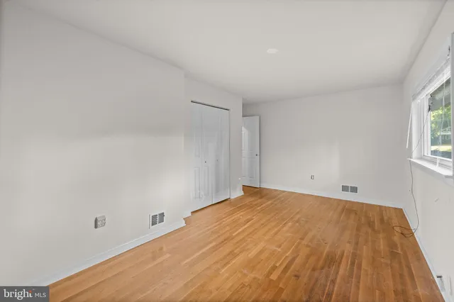 a view of a room with wooden floor and white walls