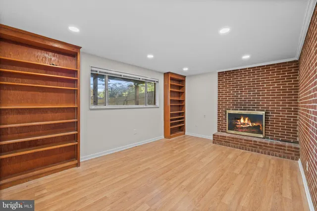 a view of an empty room with a fireplace and a window