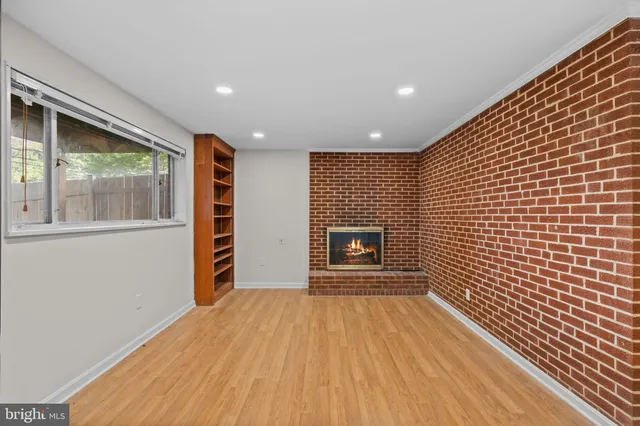 a view of empty room with wooden floor and fireplace