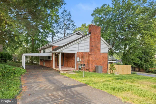 a view of a house with a yard and large tree