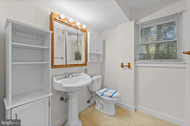 a bathroom with a sink toilet and a mirror
