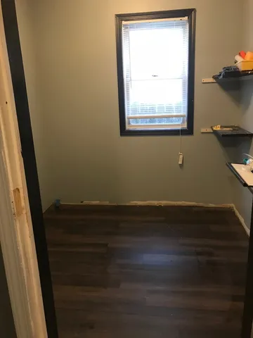 a view of a small space with wooden floor and a window