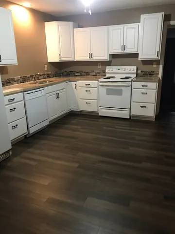 a kitchen with granite countertop a stove sink and cabinets