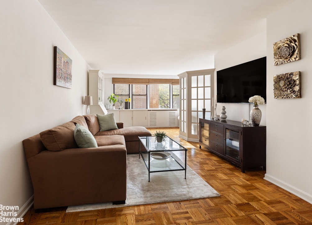 201 East 21st Street, Unit 5G Manhattan, NY 10010 - Photo 2 of 7 a living room with furniture and a flat screen tv