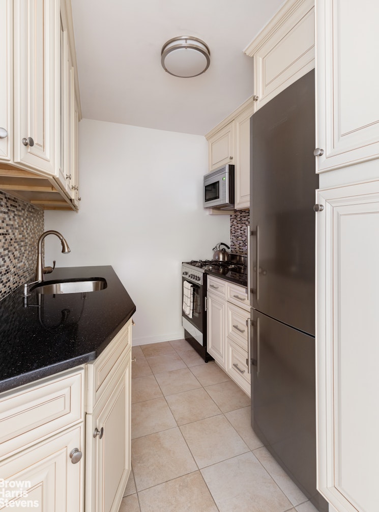 201 East 21st Street, Unit 5G Manhattan, NY 10010 - Photo 4 of 7 a kitchen with a refrigerator sink and cabinets