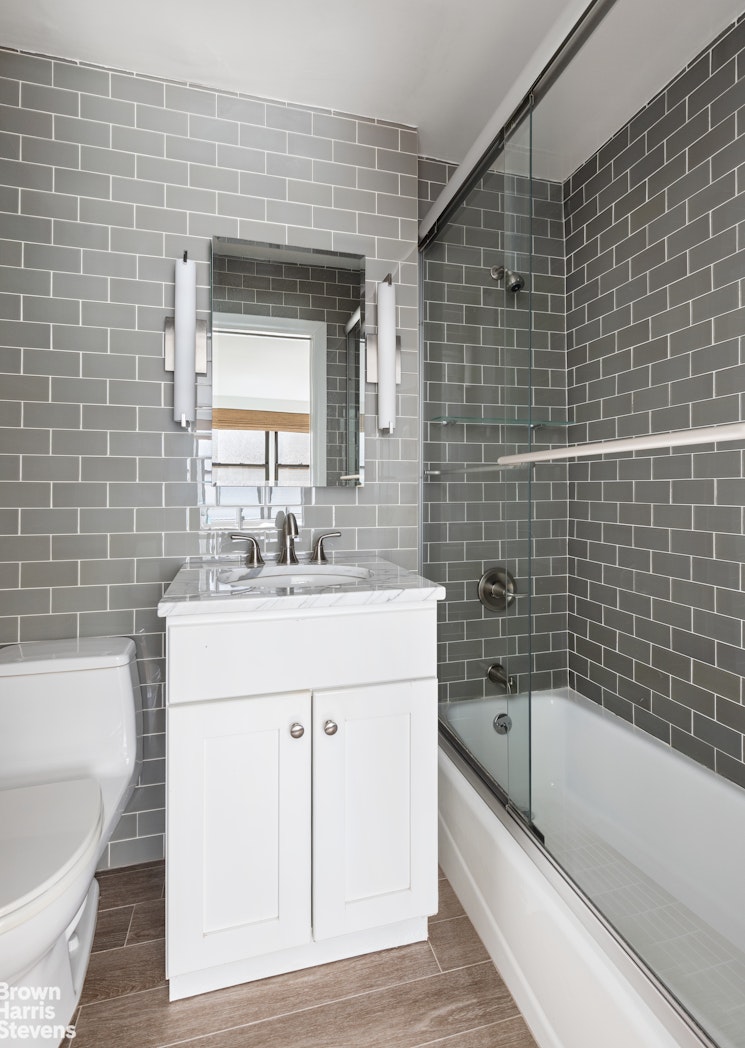 201 East 21st Street, Unit 5G Manhattan, NY 10010 - Photo 6 of 7 a bathroom with a sink a bathtub and a shower
