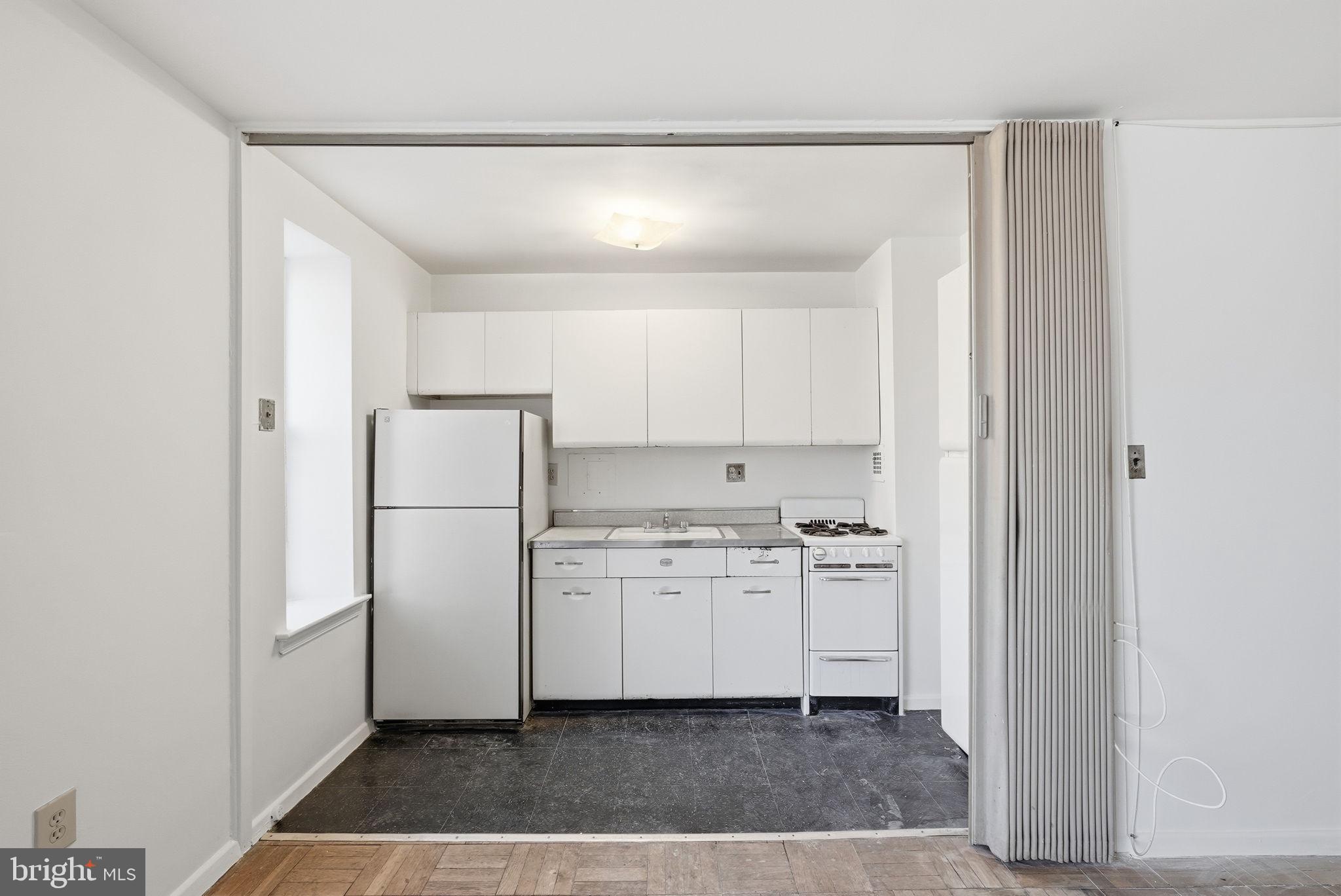 4100 W Street Northwest, Unit 203 Washington, DC 20007 - Photo 8 of 18 a kitchen with a refrigerator a stove and cabinets