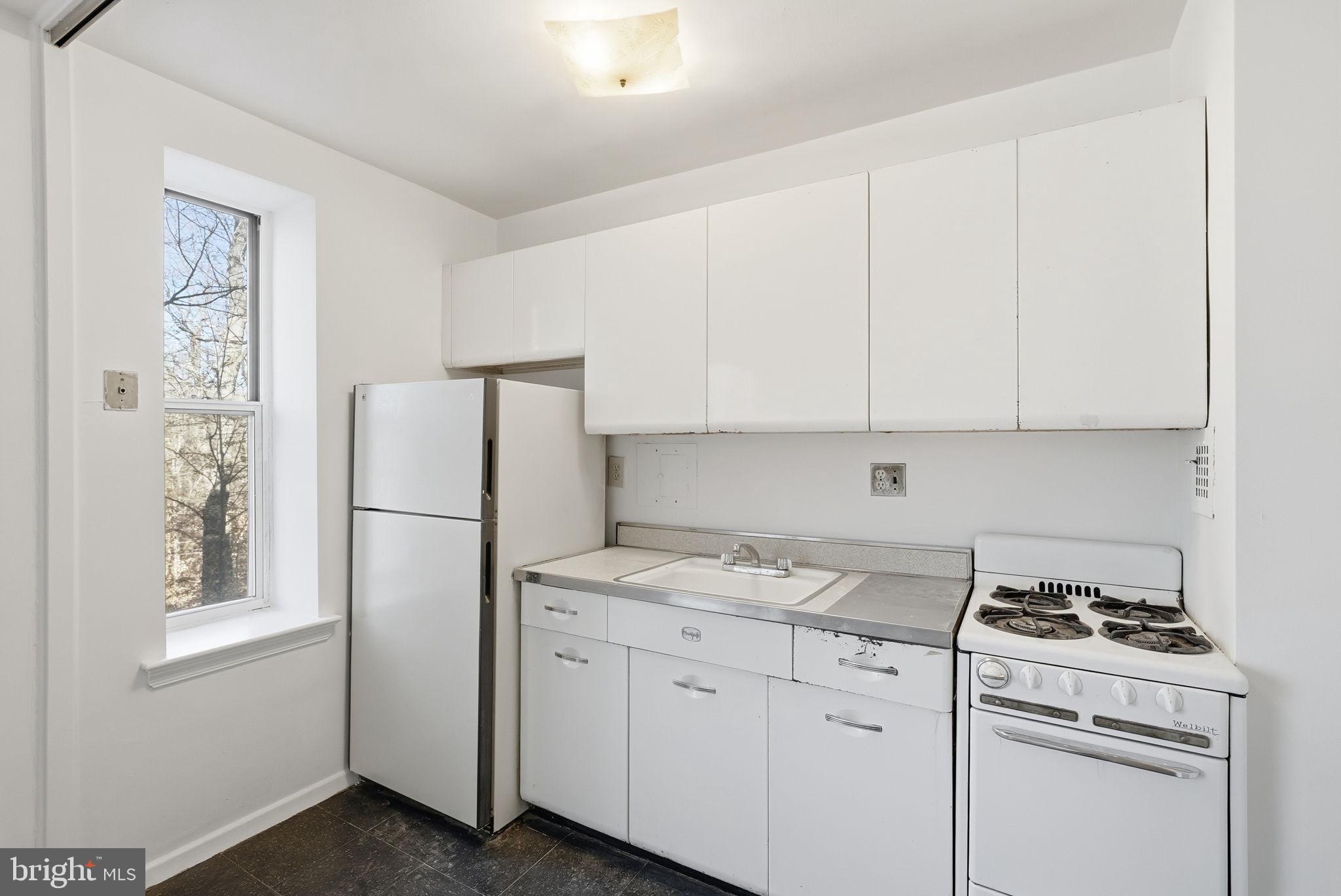 4100 W Street Northwest, Unit 203 Washington, DC 20007 - Photo 9 of 18 a kitchen with appliances a refrigerator a stove and white cabinets