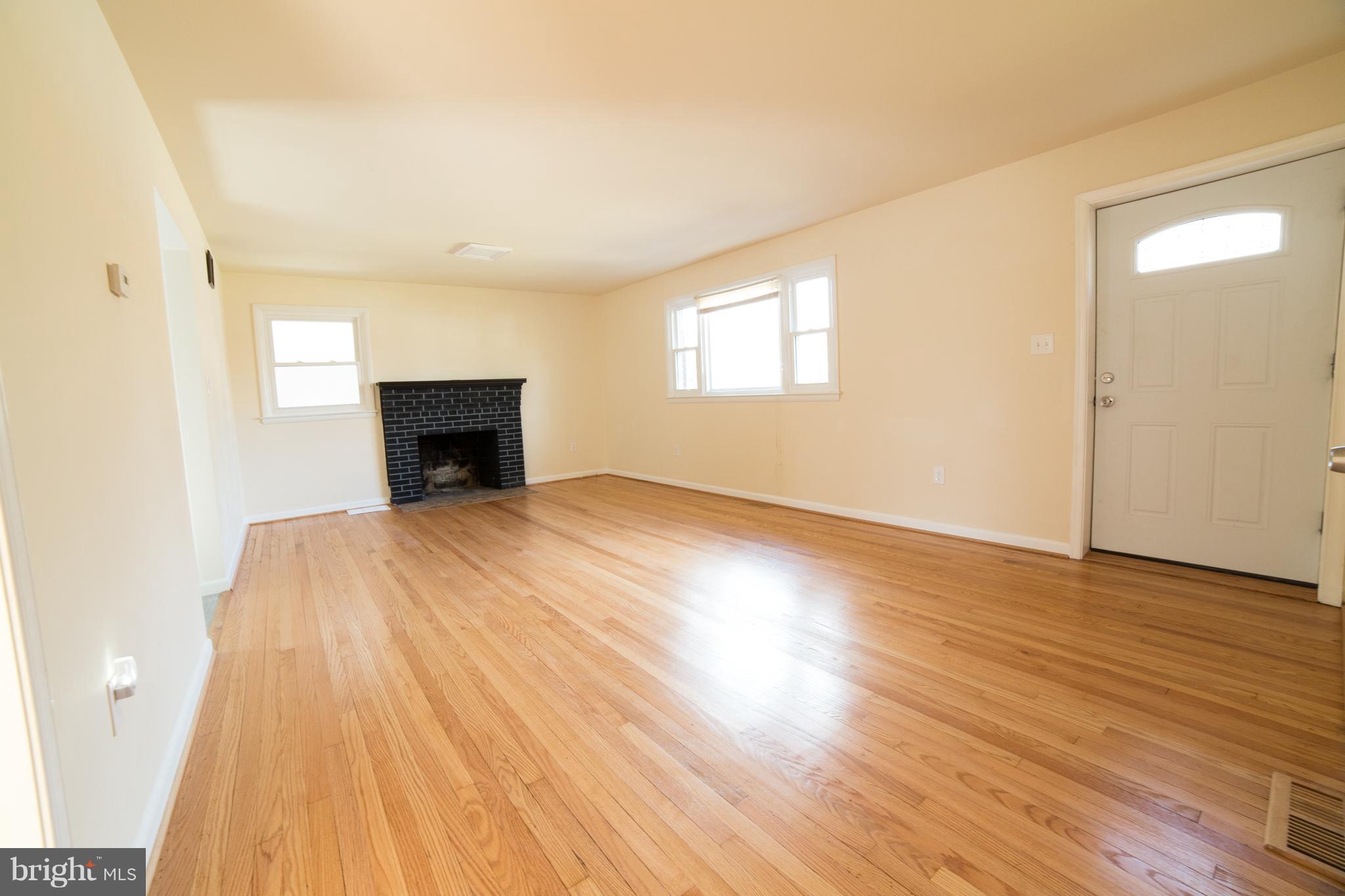 7106 Calamo Street Springfield, VA 22150 - Photo 4 of 30 wooden floor in an empty room with a fireplace