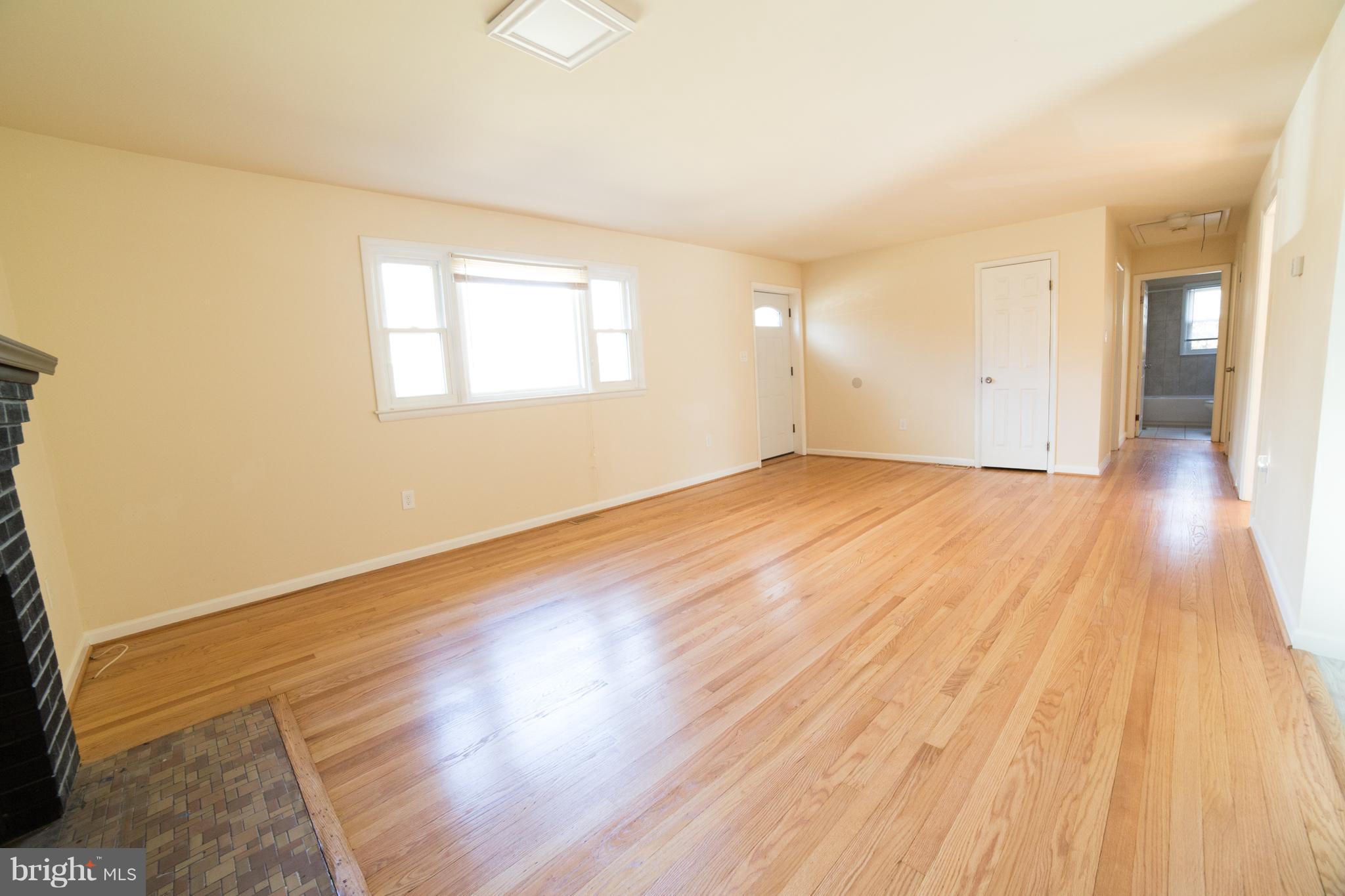 7106 Calamo Street Springfield, VA 22150 - Photo 5 of 30 an empty room with wooden floor and windows