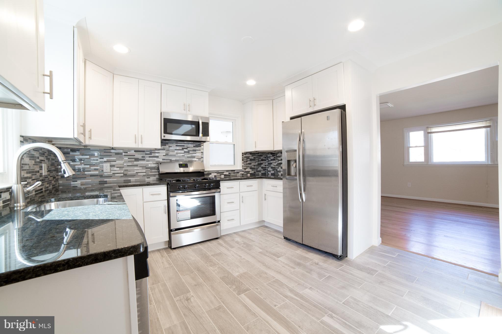 7106 Calamo Street Springfield, VA 22150 - Photo 9 of 30 a kitchen with granite countertop a refrigerator and a sink