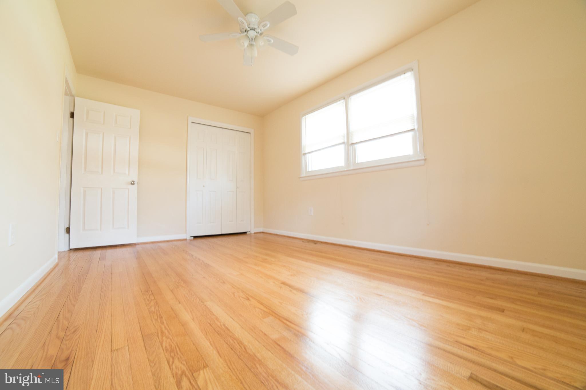 7106 Calamo Street Springfield, VA 22150 - Photo 10 of 30 an empty room with wooden floor and windows
