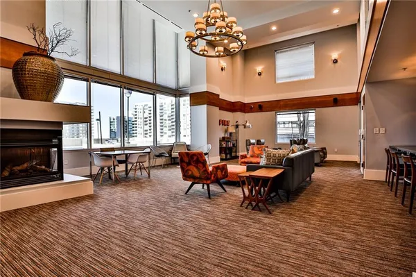 a outdoor living room with furniture a fireplace and a chandelier