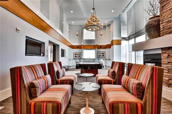 a living room with blue couches chair and couches with wooden floor