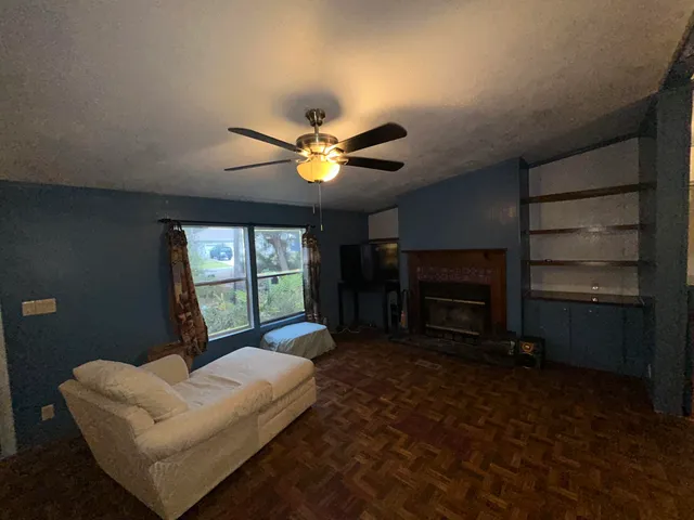 a living room with furniture a fireplace and a large window