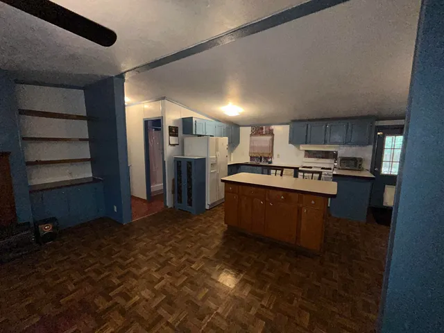 a kitchen with stainless steel appliances granite countertop a refrigerator a stove and a sink with wooden cabinets