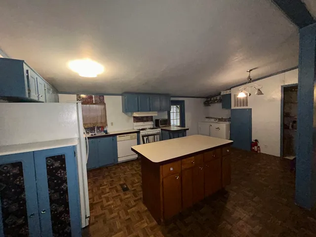 a kitchen with kitchen island a sink stove and refrigerator