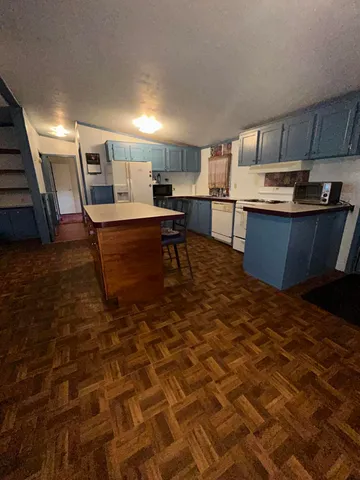 a kitchen with stainless steel appliances kitchen island granite countertop a sink and cabinets