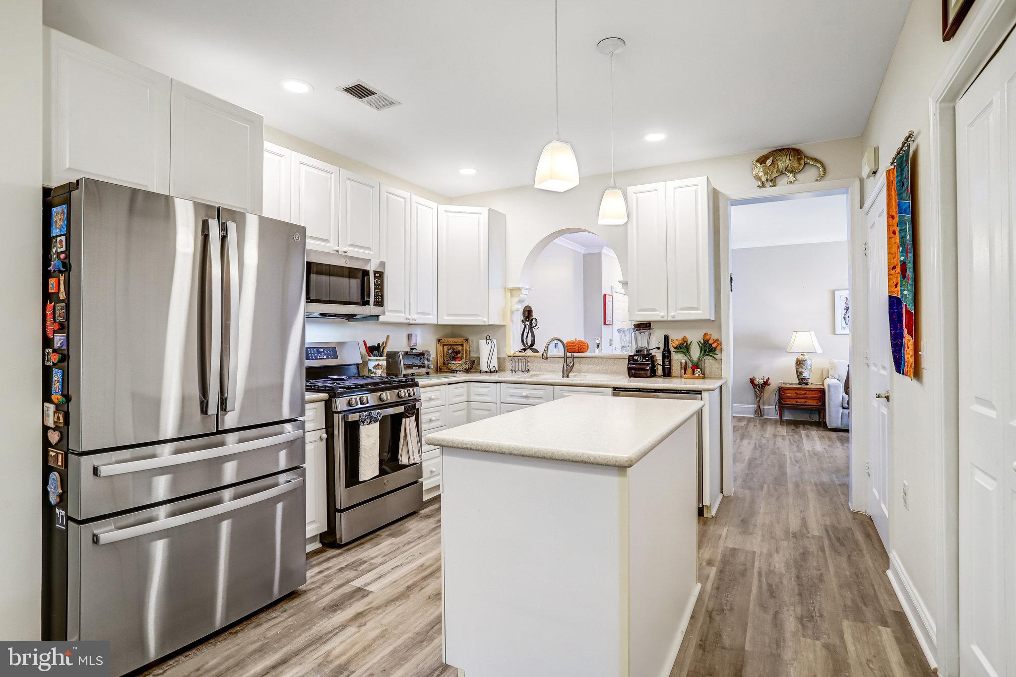 2500 Waterside Drive, Unit 303 Frederick, MD 21701 - Photo 10 of 47 a kitchen with cabinets stainless steel appliances and wooden floor