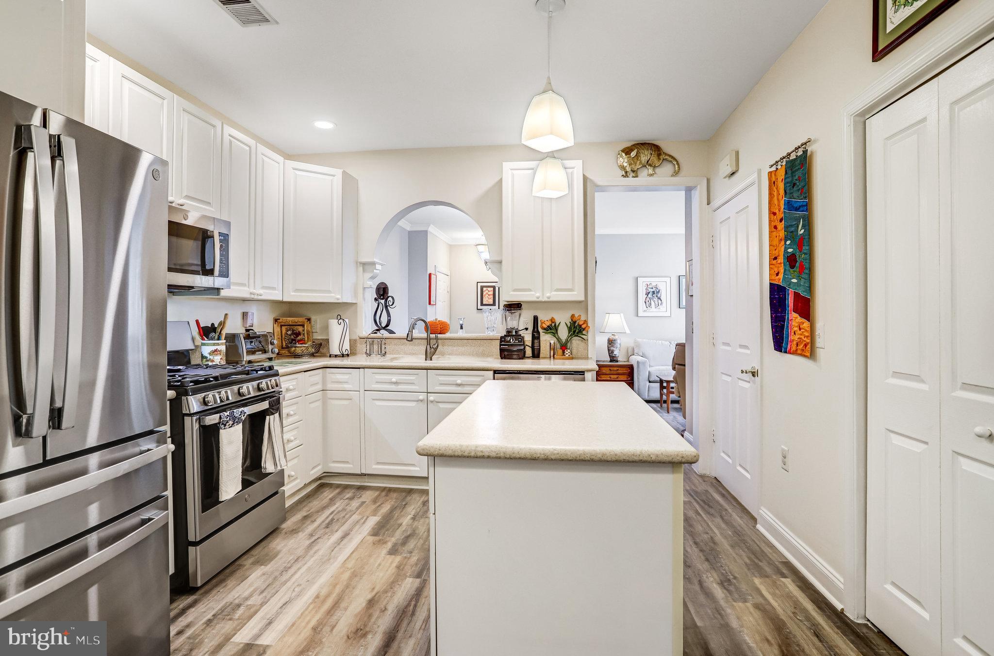2500 Waterside Drive, Unit 303 Frederick, MD 21701 - Photo 11 of 47 a kitchen with stainless steel appliances kitchen island granite countertop a refrigerator a stove and a sink with large cabinets