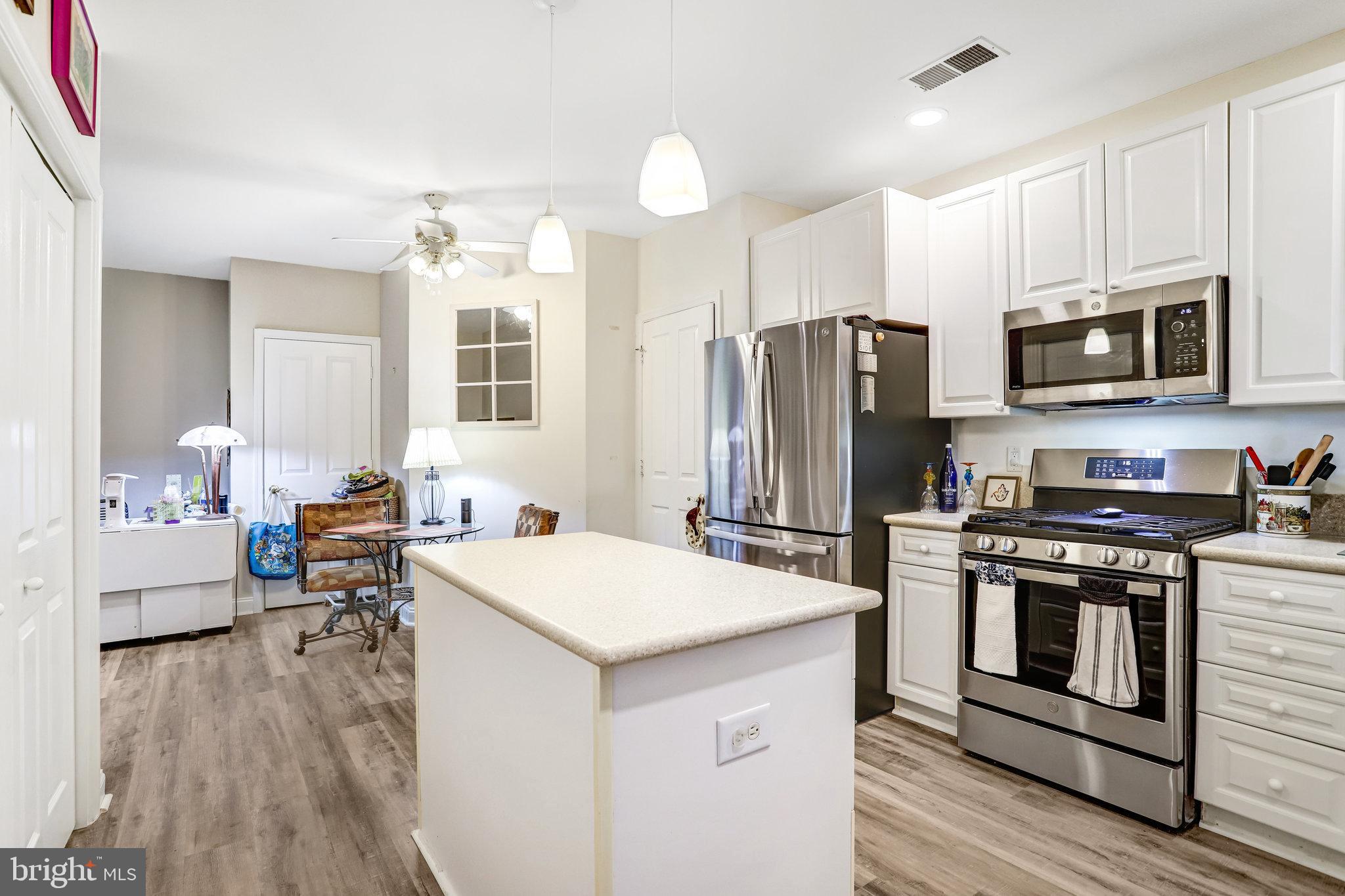 2500 Waterside Drive, Unit 303 Frederick, MD 21701 - Photo 9 of 47 a kitchen that has a sink cabinets stainless steel appliances and wooden floor