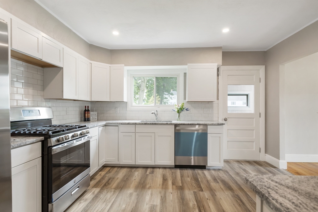 26 Riverside Drive Dedham, MA 02026 - Photo 15 of 35 a kitchen with granite countertop stainless steel appliances a stove sink and microwave