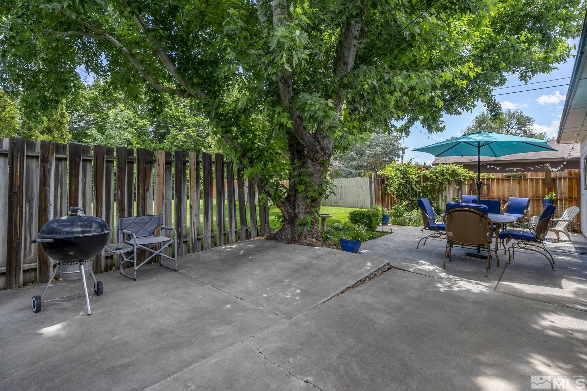 620 Cardinal Way Reno, NV 89509 - Photo 16 of 18 a view of a patio with a table and chairs under an umbrella with wooden fence