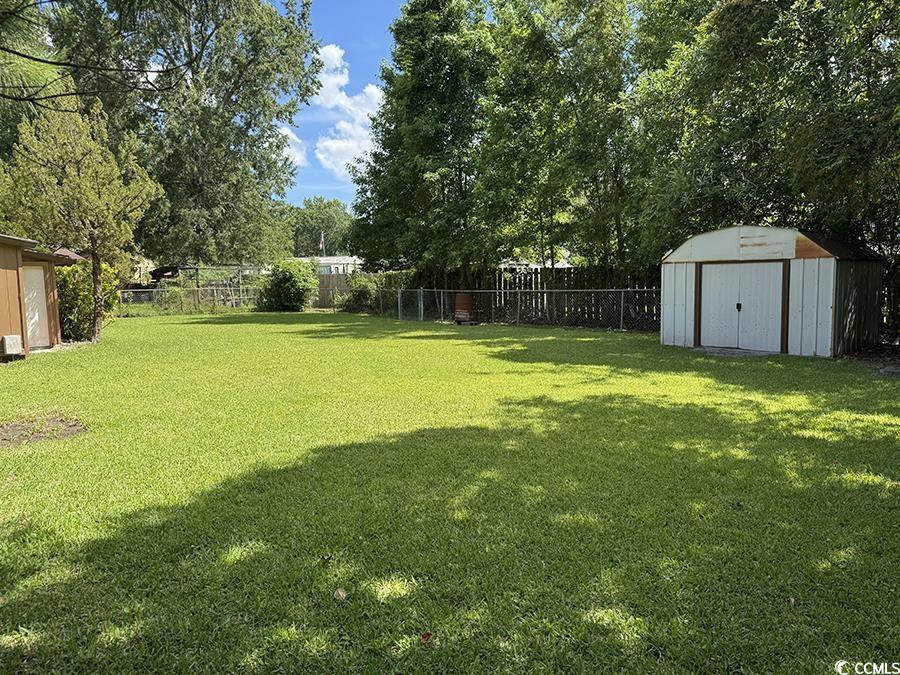 4041 Long Line Lane Myrtle Beach, SC 29579 - Photo 15 of 20 Fenced backyard with a storage unit and view of wo