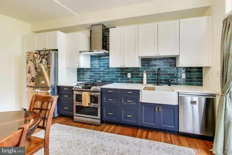 a kitchen with stainless steel appliances granite countertop a stove a sink and a refrigerator