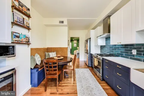 a kitchen with stainless steel appliances granite countertop table chairs sink and cabinets
