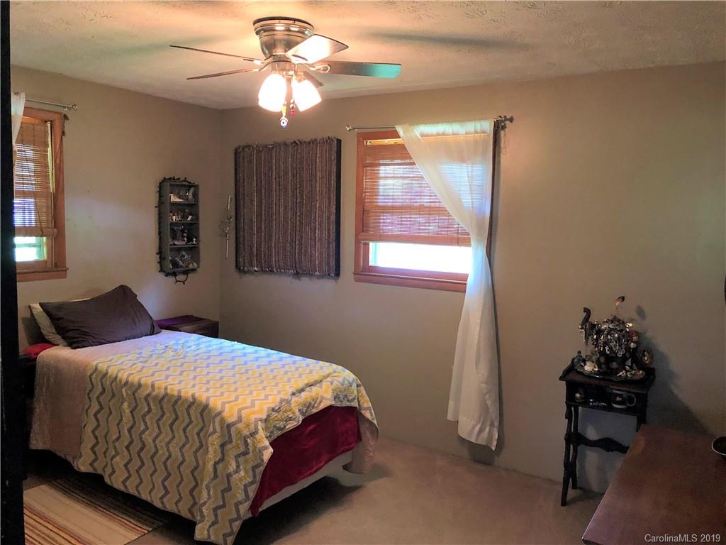 87 Cresent Loop Canton, NC 28716 - Photo 12 of 31 a bedroom with a bed and a chandelier
