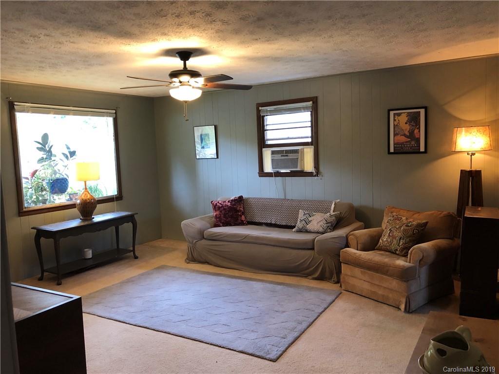 87 Cresent Loop Canton, NC 28716 - Photo 6 of 31 a living room with furniture a chandelier and a flat screen tv