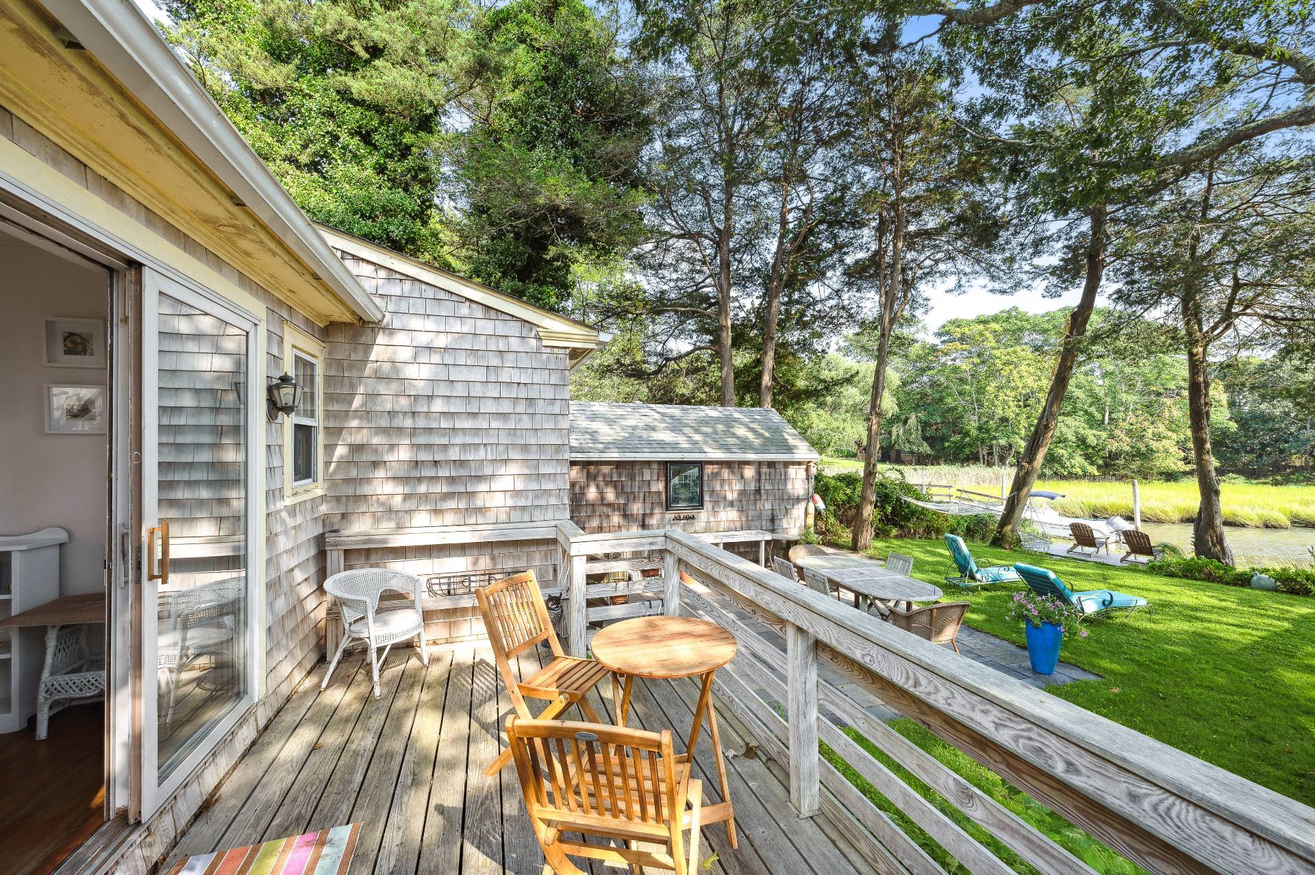 64 Towd Point Road Southampton, NY 11968 - Photo 14 of 21 a view of a patio with table and chairs and wooden floor