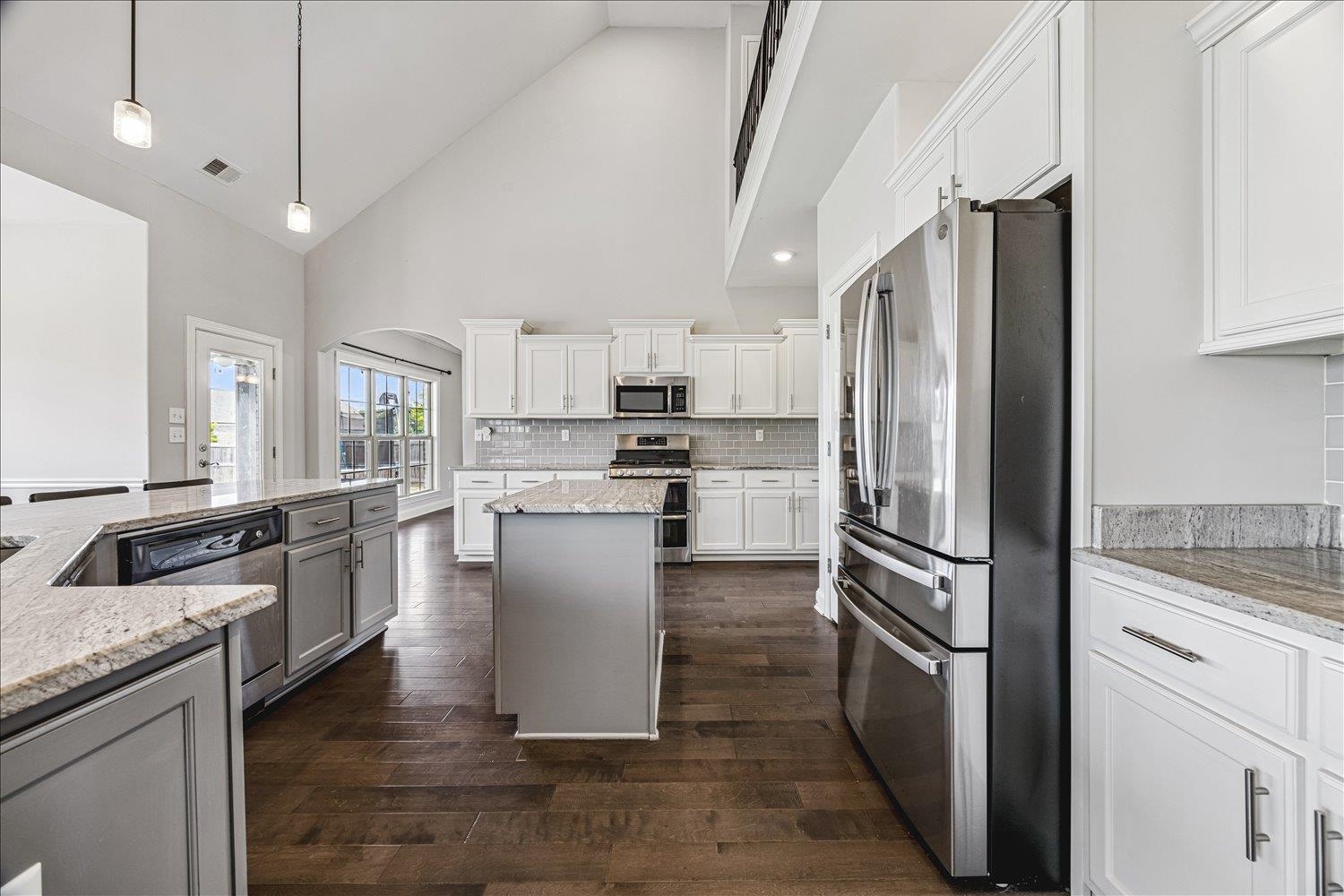 12802 Longmire Loop South Arlington, TN 38002 - Photo 12 of 40 a kitchen with granite countertop a refrigerator a sink a stove and cabinets