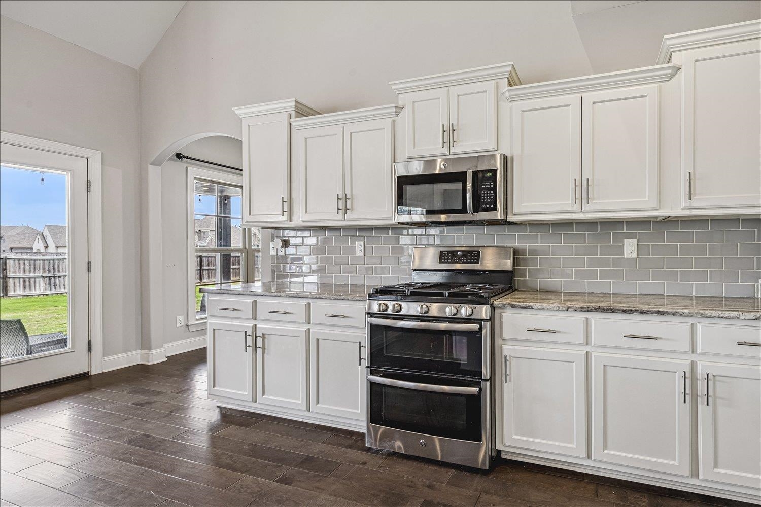 12802 Longmire Loop South Arlington, TN 38002 - Photo 13 of 40 a kitchen with stainless steel appliances granite countertop a stove a sink and white cabinets