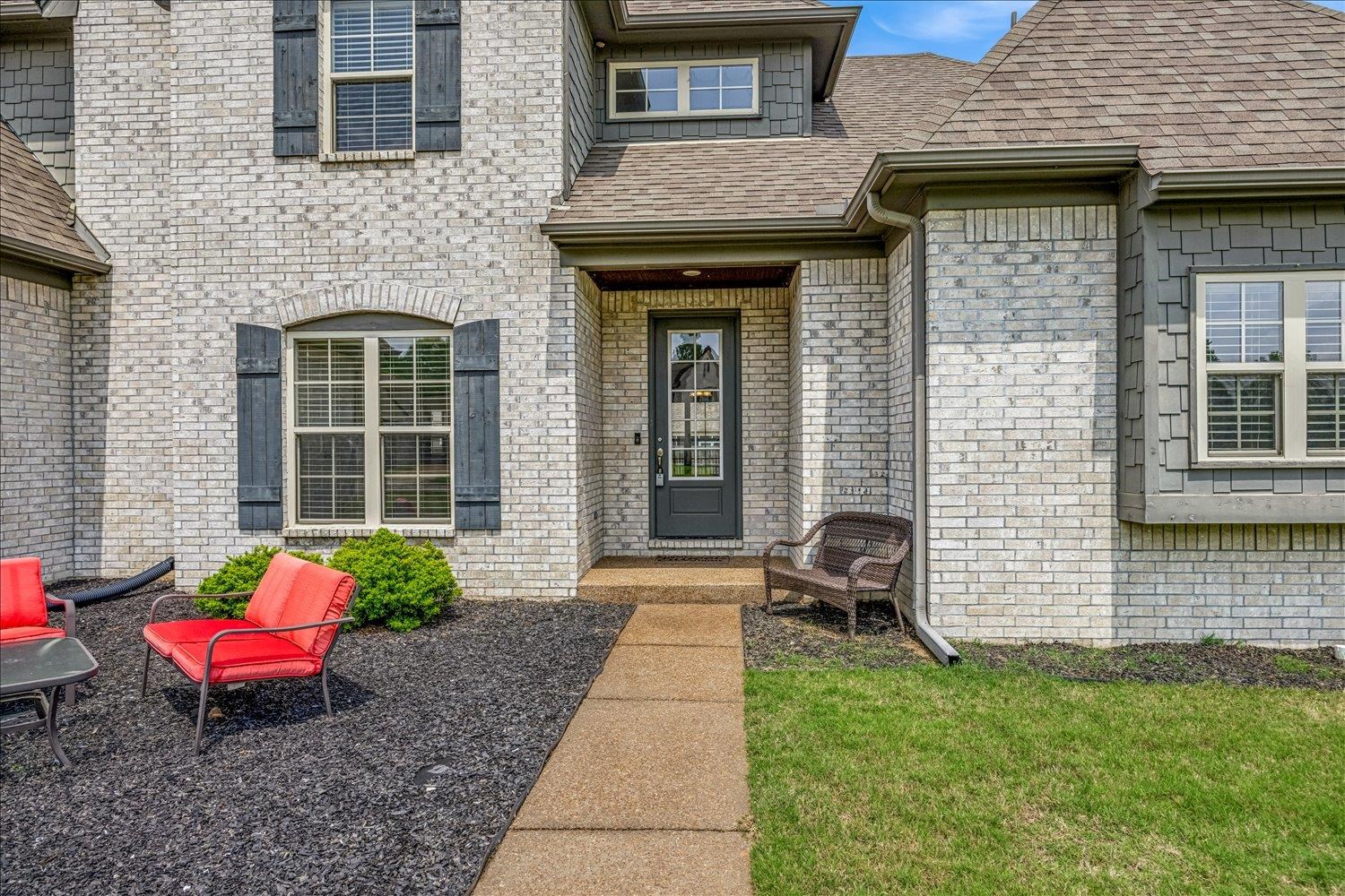 12802 Longmire Loop South Arlington, TN 38002 - Photo 3 of 40 a view of a brick house with a chairs and table in a patio