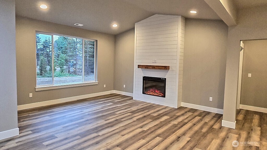 573 Monte Elma Road Montesano, WA 98563 - Photo 10 of 13 a view of empty room with wooden floor and fireplace