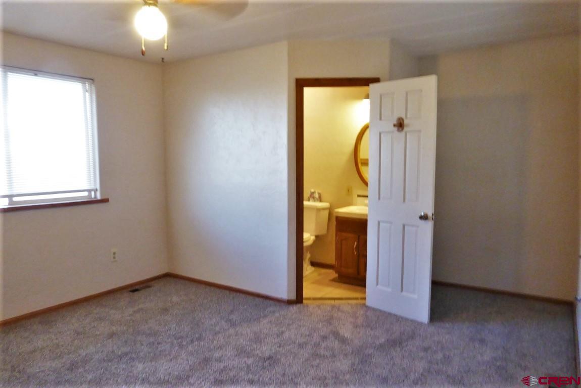 25352 Cedar Mesa Road Cedaredge, CO 81413 - Photo 14 of 32 an empty room with a window and a bathroom