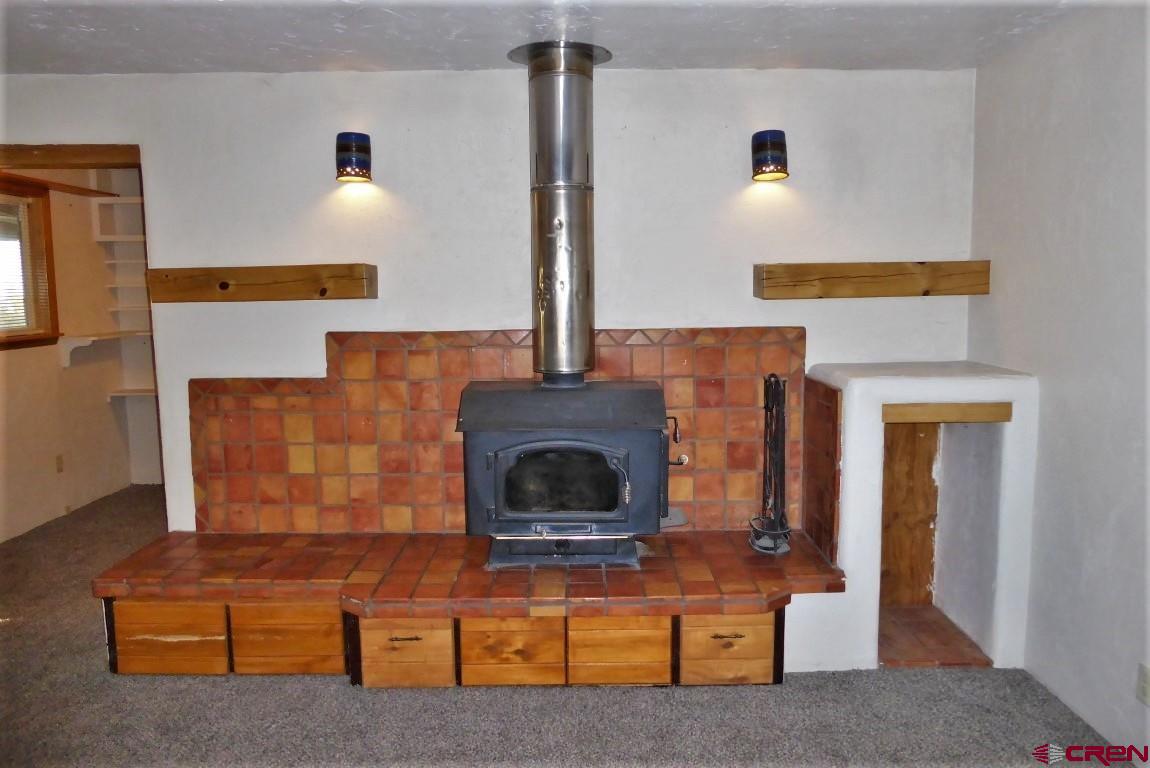 25352 Cedar Mesa Road Cedaredge, CO 81413 - Photo 4 of 32 a living room with furniture and a fireplace
