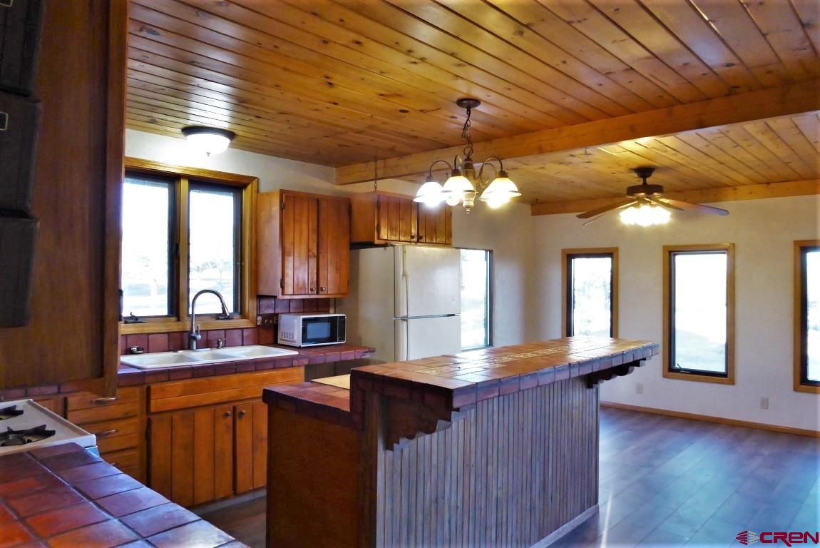 25352 Cedar Mesa Road Cedaredge, CO 81413 - Photo 5 of 32 a kitchen with counter top space and wooden floor