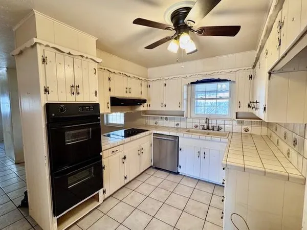 a kitchen with a stove a sink and a refrigerator