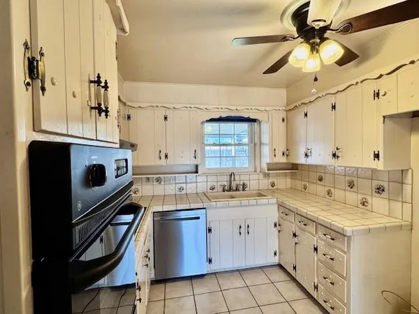 a kitchen with a sink stove and cabinets