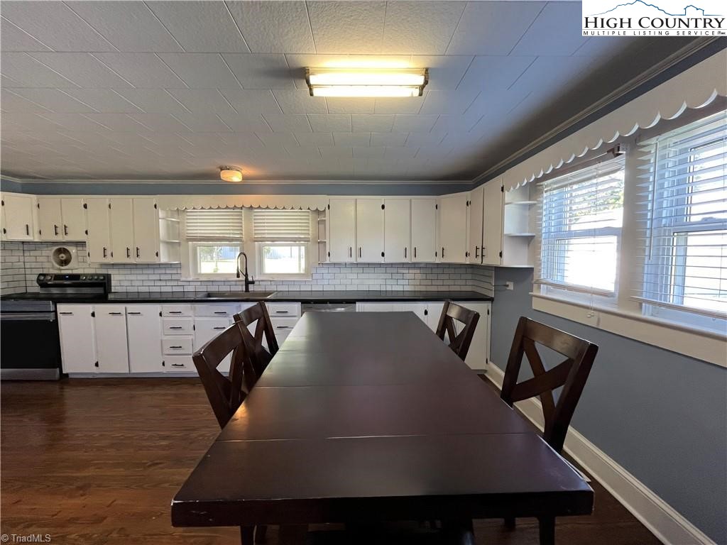 820 Suncrest Orchard Road North Wilkesboro, NC 28659 - Photo 19 of 41 a kitchen with a table chairs a sink dishwasher window and cabinets