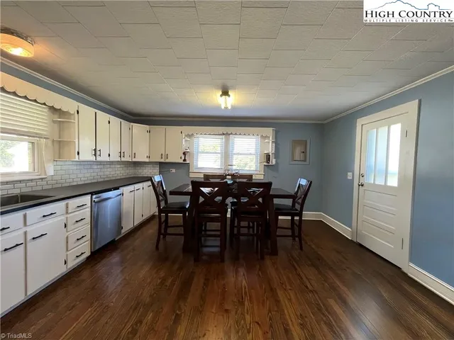 a kitchen with stainless steel appliances granite countertop a refrigerator a sink dishwasher a stove and white countertops with wooden floor