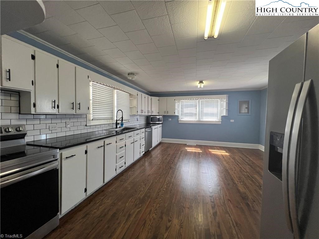 820 Suncrest Orchard Road North Wilkesboro, NC 28659 - Photo 22 of 41 a kitchen with stainless steel appliances granite countertop a refrigerator a sink dishwasher a stove and white countertops with wooden floor