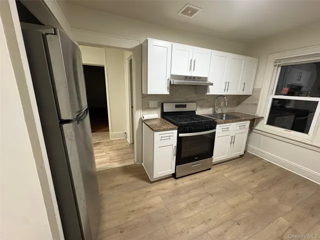 a kitchen with a sink a refrigerator a stove a microwave and cabinets