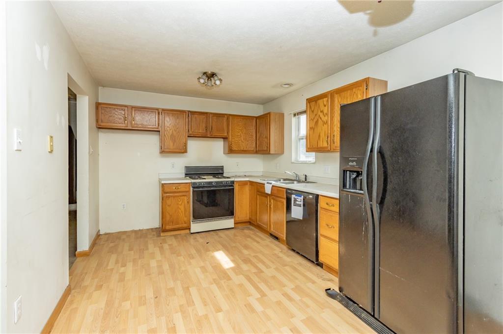 333 Butler Street Springdale, PA 15144 - Photo 8 of 17 a kitchen with granite countertop a refrigerator and a stove top oven