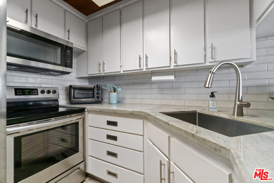 6209 Pacific Avenue, Unit 103 Playa del Rey, CA 90293 - Photo 10 of 40 a kitchen with stainless steel appliances granite countertop a sink and a microwave